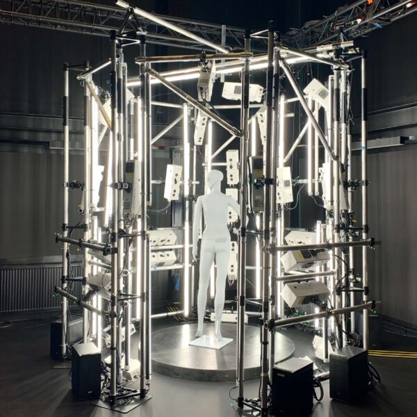 Volumetric capture studio setup in a laboratory. A mannequin is inside the system surrounded by cameras and booms of the studio setup.